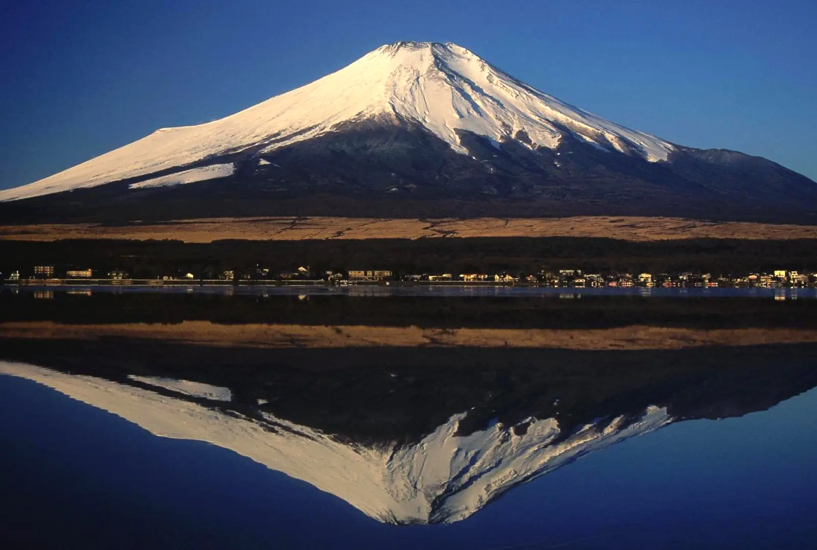 Mt Fuji mirrored in still water on Lake Yamanaka on a clear February morning