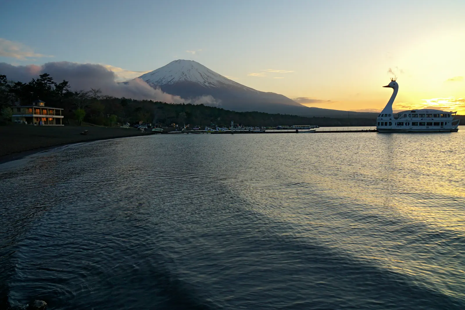 Evening light on Lake Yamanaka, with Mount Fuji on the skyline and the white swan-shaped cruise boat at its pier on the right
