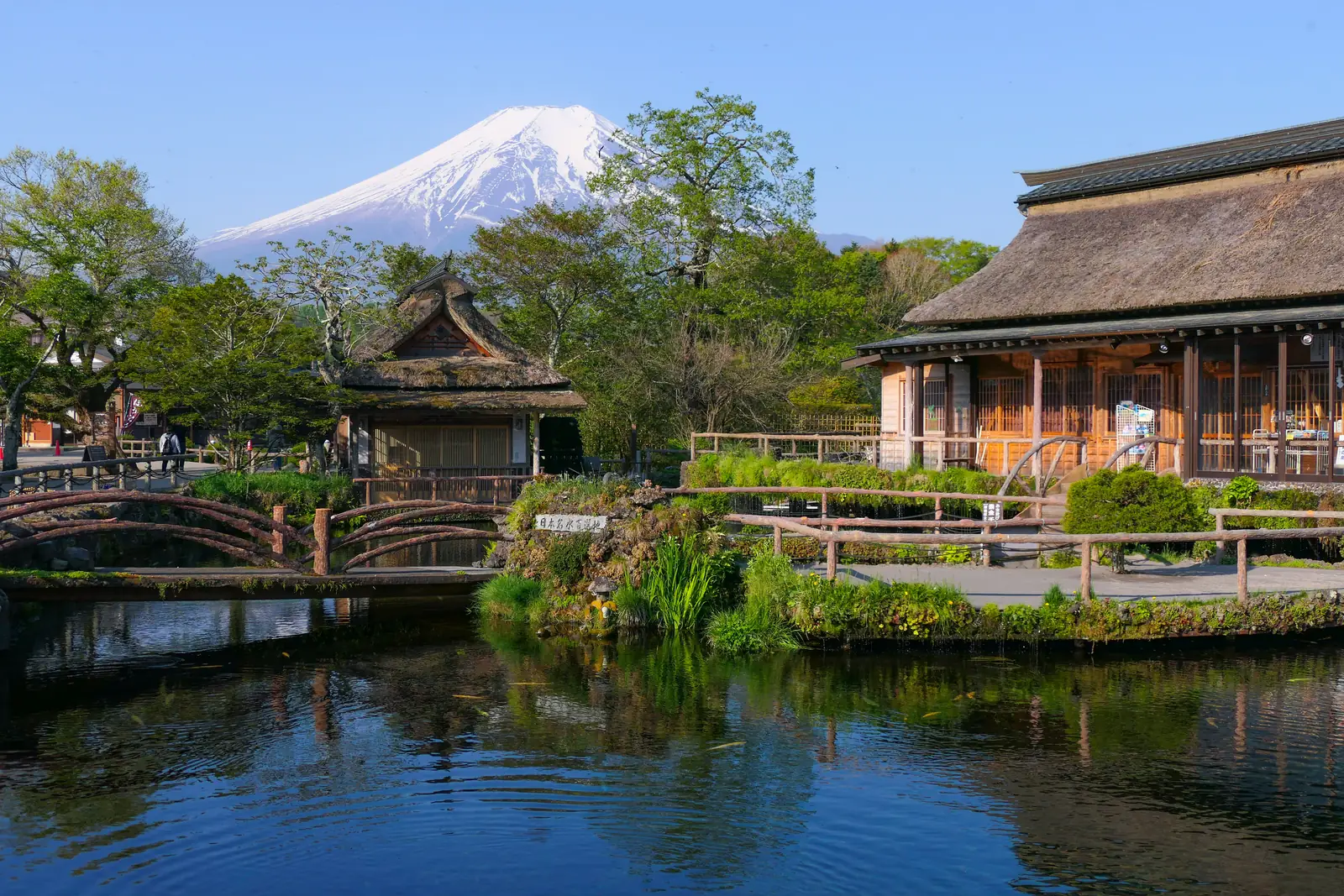 Naka-ike pond in Oshino village with thatched buildings and Mount Fuji behind